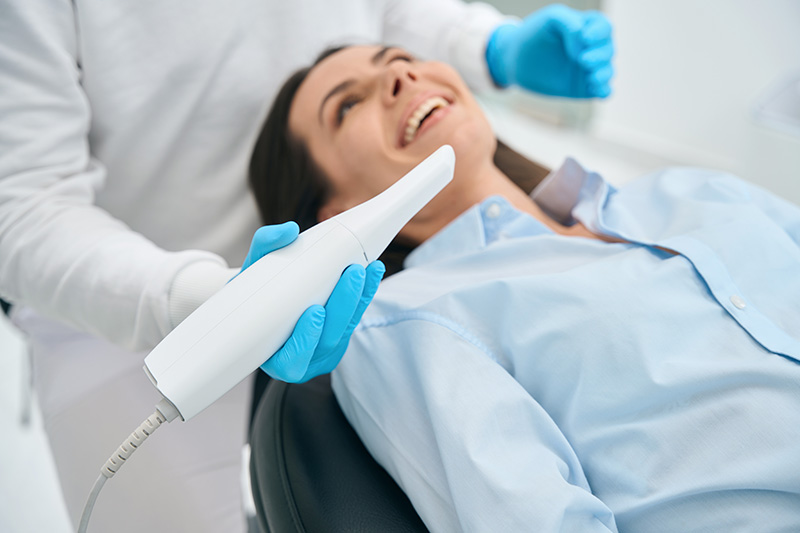 Zahnärztin untersucht mit einer Intraoralkamera den Mund einer Patientin, um mögliche Zahnprobleme genau zu erkennen.